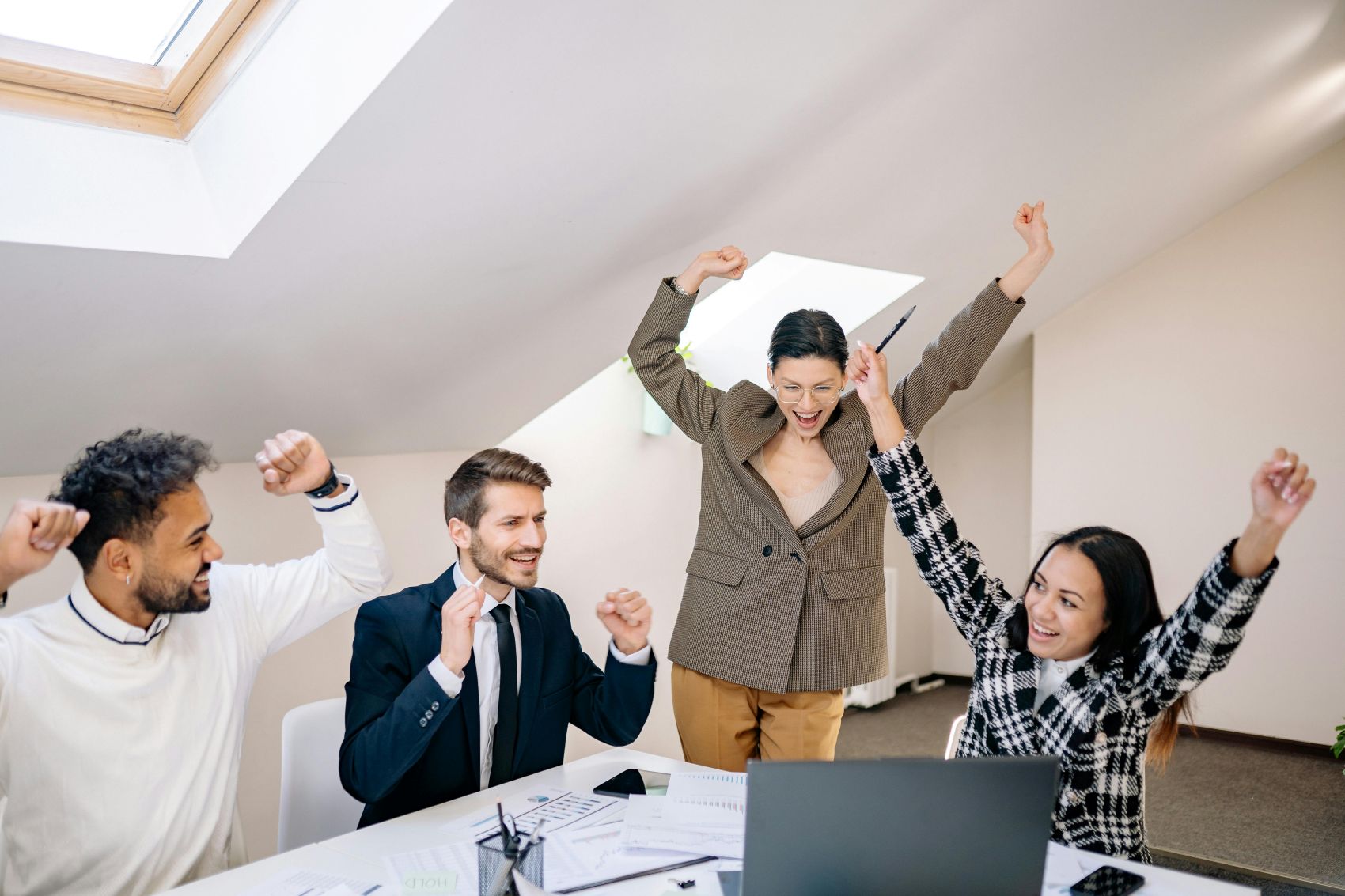 4 collega's die met elkaar juichen en werkgeluk ervaren.